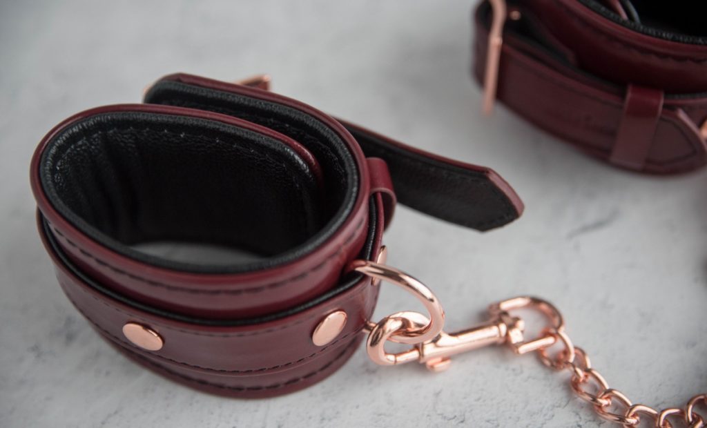 Liebe Seele Wine Red Cuffs review. The top-down view of the cuffs. One end of the rose gold chain is clipped onto the D-ring as well. The second cuff can be seen in the background.