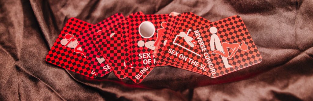 A set of oral sex position playing cards sitting out on a bed as part of the Tracy's Dog WOW Holiday box