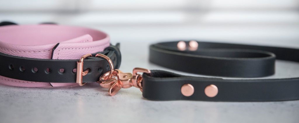 Close-up of the scissor snap / lobster claw hardware on the end of the leash. This allows the leash to fit virtually any collars. It's a very roomy, easy-to-use clip in a matching rose gold color. Mercy Industries Collar Review image.