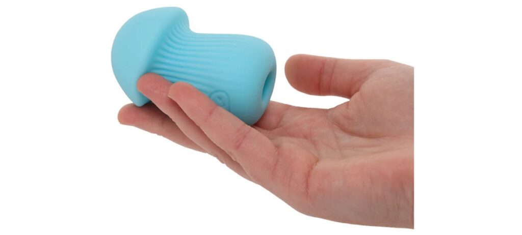 A small penis stroking sleeve rests on someone's palm. It's very short in length. 