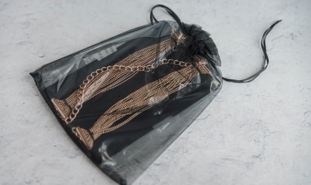Both of the bracelets inside of a black, mesh, drawstring bag for easy storage. Secret Kisses Luxe Gold Bracelet Cuffs Review image.
