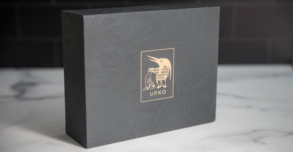 Packaging for the ankle cuffs. They come in a plain black, textured box that has the UPKO logo emblazoned in a beautiful gold foil on the front. It's a very sturdy box. UPKO Butterfly Effect Ankle Cuffs review image.