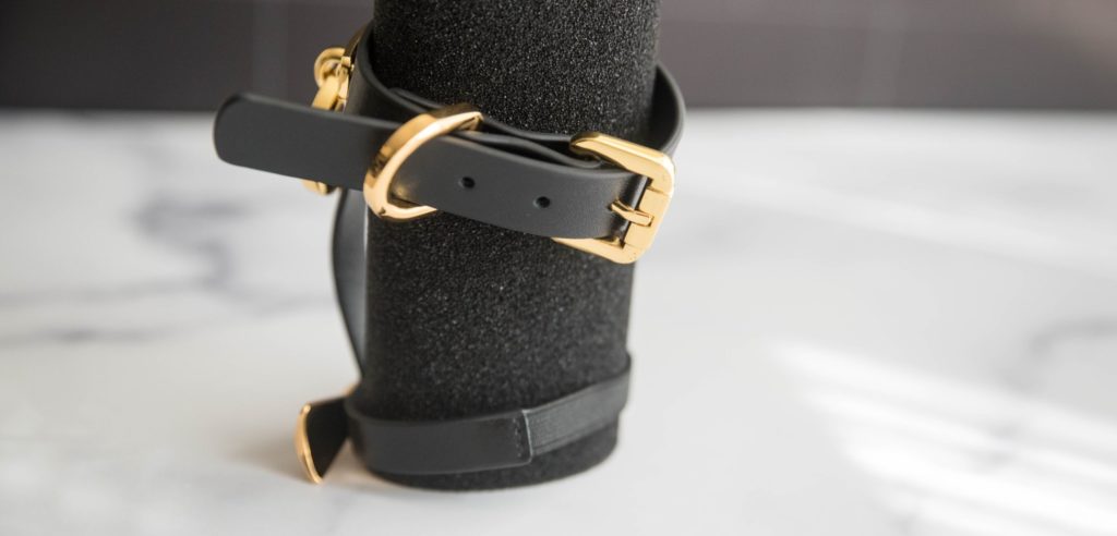 Close-up of the two places where adjustments are made to fit different foot sizes. The bottom strap, that rests under the foot, uses an elastic band that stretches. The top strap, that wraps around the ankle, uses a metal, gold buckle that works like a belt you'd use around the hips. UPKO Butterfly Effect Ankle Cuffs review image.