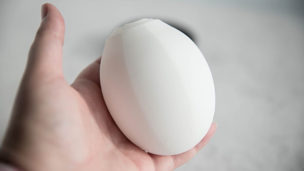 I hold the Tenga GEO in my hand. It's inside out, and the texture is facing the inside. This leaves an egg-looking, smooth object in my hand. It looks white, smooth, and textureless. For my Tenga GEO review.