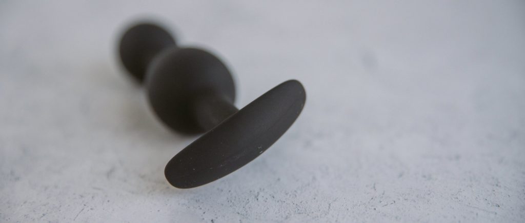 Close up of the base of the Holly Fuck II butt plug. It is more like a line and is clearly curved to help it rest naturally up against the curvature of the body.