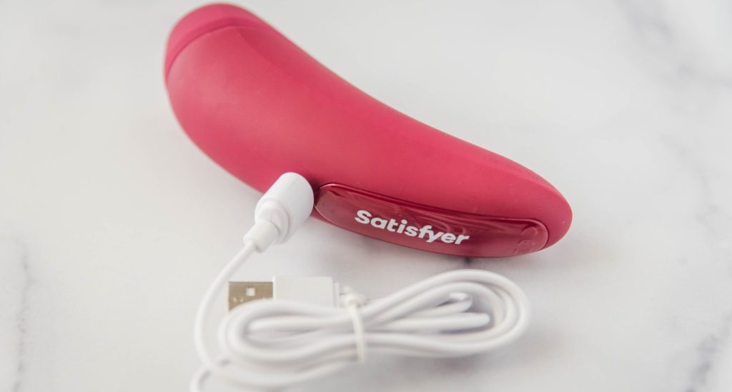 The charging cable plugged into the Satisfyer Curvy 1. It's a magnetic charging cable, and it doesn't actually have to plug "in" to the vibrator. For my Satisfyer Curvy 1 review.
