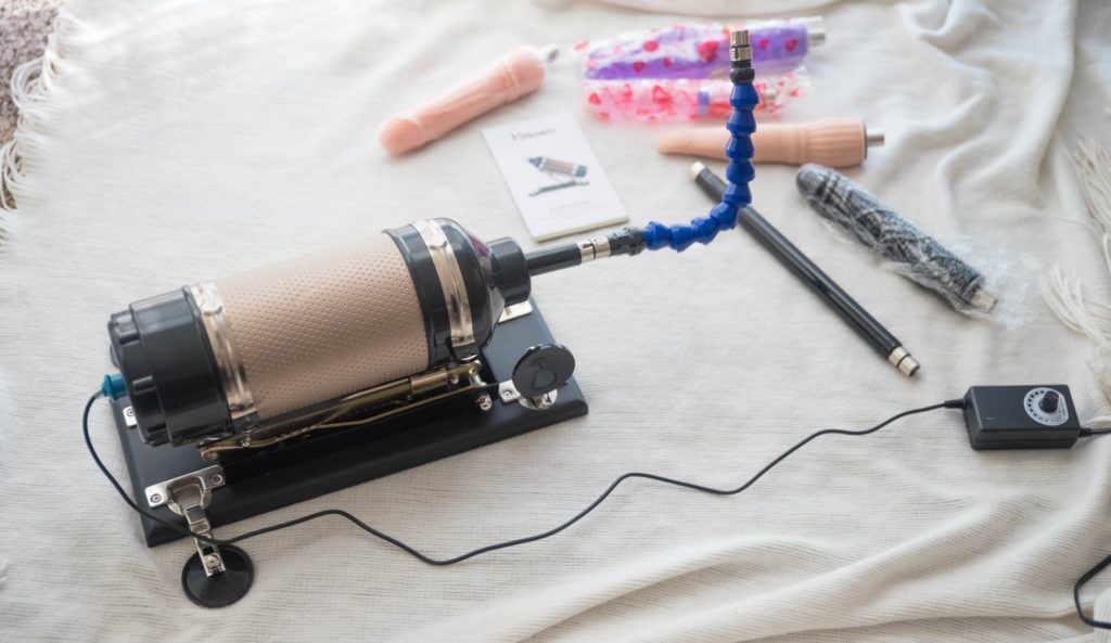 The bendable extender attached to the sex machine without a dildo on the other side. The power cord with attached remote control is shown as extended as far as possible. The remote barely extends further than the area where the dildo is which may make it hard to control the thrusting while actively using the machine. For Hismith Sex Machine Review 3XLR version.