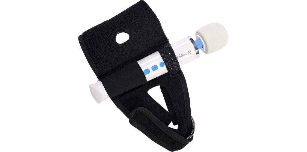A harness that can fit a thigh dildo is shown. There is a wand massager attached to the other loop built into the thigh harness.