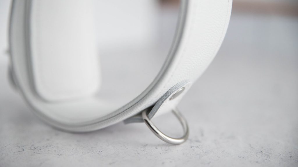 Close-up of a D-ring from the surface of the cuff. The D-ring is flipped outwards, protruding from the surface of the collar. It's D-shaped with a lot of room to add accessories within the ring.