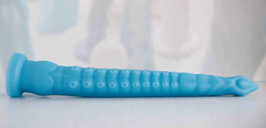 A long, horizontal image showing the tentacle dildo simply laying out flat to the camera. It looks like a VERY long toy. Image for my MEO.de Long Anal Tentacle Dildo Review.