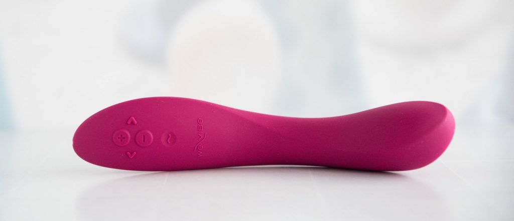 The We-Vibe Rave 2 laying out on its side. The tip of the vibrator is the thickest point of the toy while the vibrator slims down in diameter towards the base of the insertable portion.