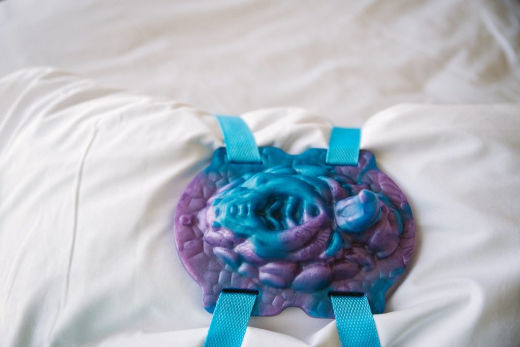 Top down view of the Coral Keeper wrapped around a pillow. This angle showcases all of the intracacies of the texture of the Coral Keeper. Everything is extremely detailed. For my Uncover Creations Coral Keeper grinder review.