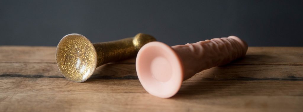 Close-up of the bottom of suction cup dildos, showcasing the concave design that helps them suction onto a flat surface for hands-free use.