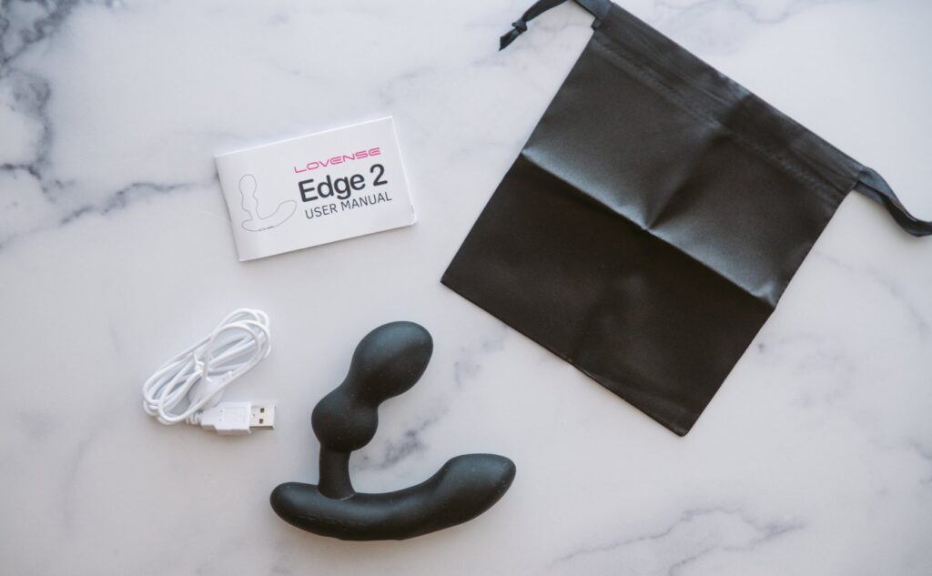 Everything that comes with the Edge 2 including the toy itself, the instruction manual, the storage bag, and the charging cable. For my Lovense Edge 2 review.