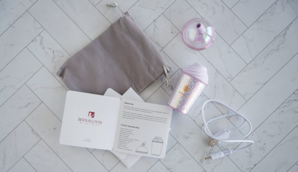 Everything that comes with the BeYourLover Cup. There's the toy, the lid, the instructions, the charging cable, and the drawstring bag. For my BeYourLover Joy Cup review.