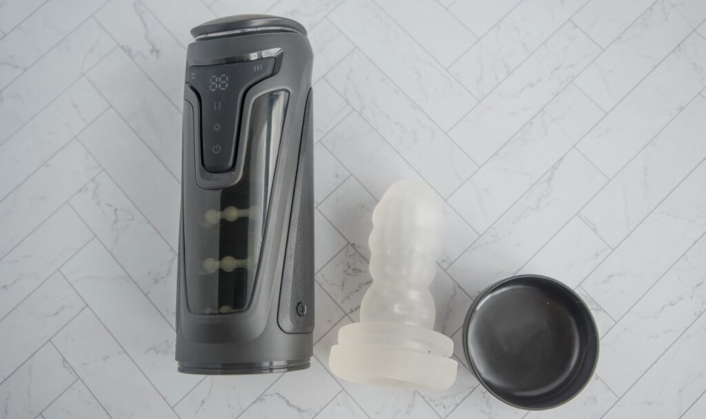 The TPE sleeve is removed from the Fleshy Thrust Sync and shown next to the cap, showcasing how all of the pieces fit together. For my Fleshy Thrust Sync Review.