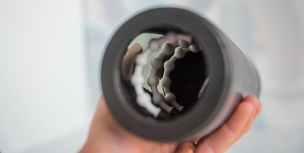 The TPE sleeve is removed from the inside of the Fleshy Thrust Sync, showcasing the inner components that allow the toy to feel pleasure. There are white, beaded rings and a vibrating motor. For my Fleshy Thrust Sync Review.