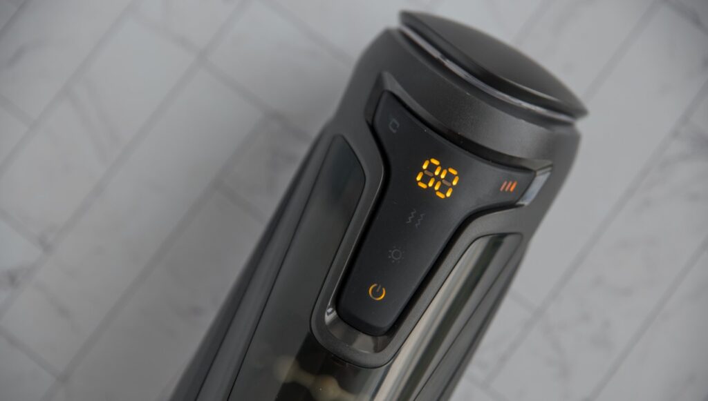 The stroker is turned on. The buttons are orange and backlit, showcasing how all of the functions have their own control button. For my Fleshy Thrust Sync Review.