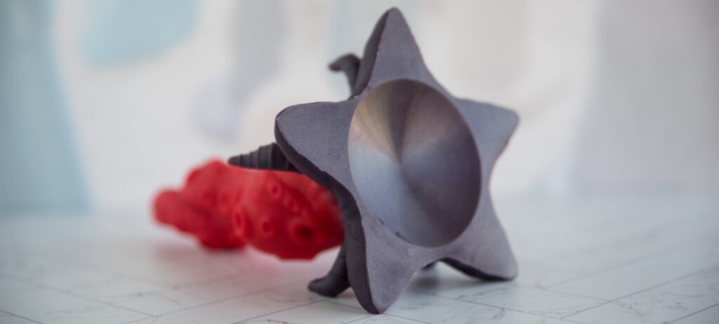 The dildo is laying on its side, and I'm photographing the base. The base has a very distinct concave design that doubles as a suction cup. The base also looks like a star. For my Juliet Toys Starfish dildo review.