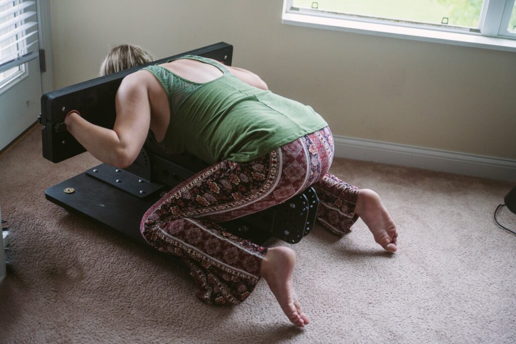 My favorite way to use the sex furniture, as a small, kneeling platform with attached stockade. The L-shaped hinge is entirely folded up onto itself and resting directly on top of the platform. My partner is fastened inside of the furniture, in a doggy style position with their butt sticking out. For my Fetdom Multi-Position Floating Stockade Pillory Review.