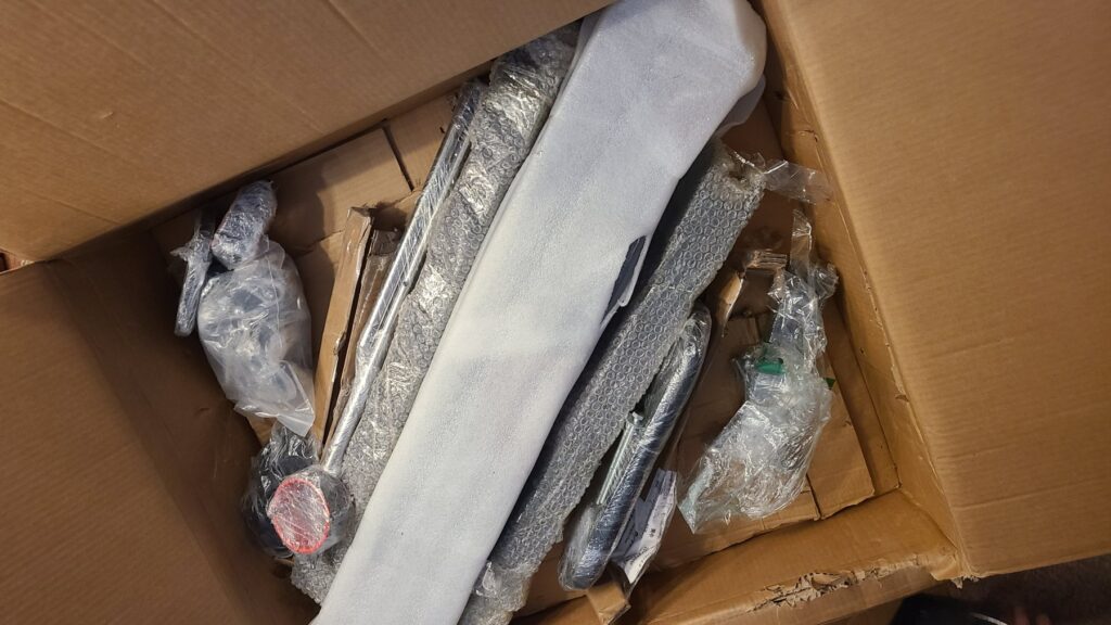 Opening up the box that this sex furniture came in. All of the various pieces are mostly "free" inside of the box, each wrapped in bubble wrap to protect them while hitting one another during transit.