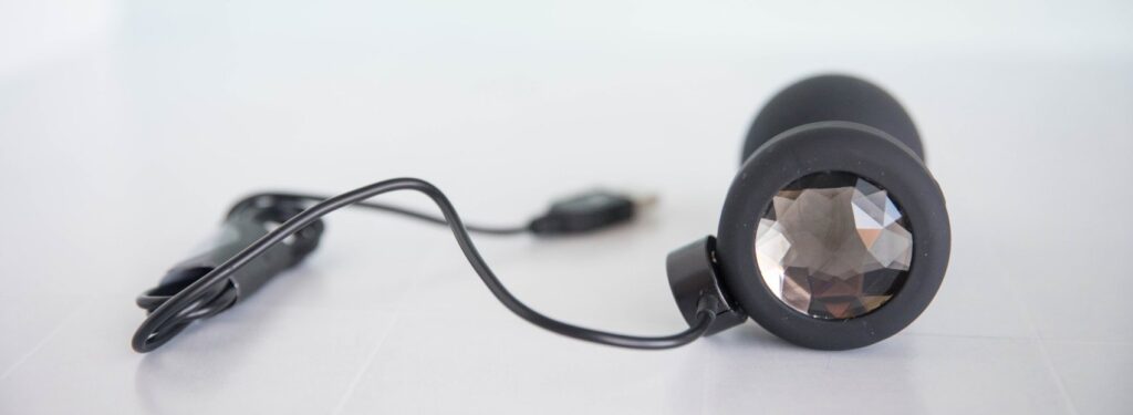 The butt plug plugged into the magnetic charging cable that will charge the plug's vibrations.