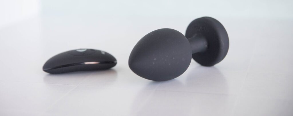 The plug and the remote control sit out next to one another. The remote is oval shaped and about 2/3rds the length of the plug's length. For my b-Vibe XXL Vibrating Jewel Plug Review.
