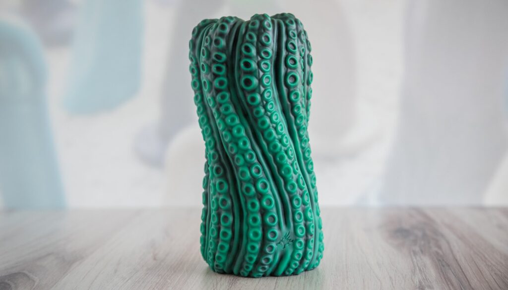 The stroker stands entirely upright without any help. The silicone is firm enough to allow the stroker to stay upright when placed on a flat surface.