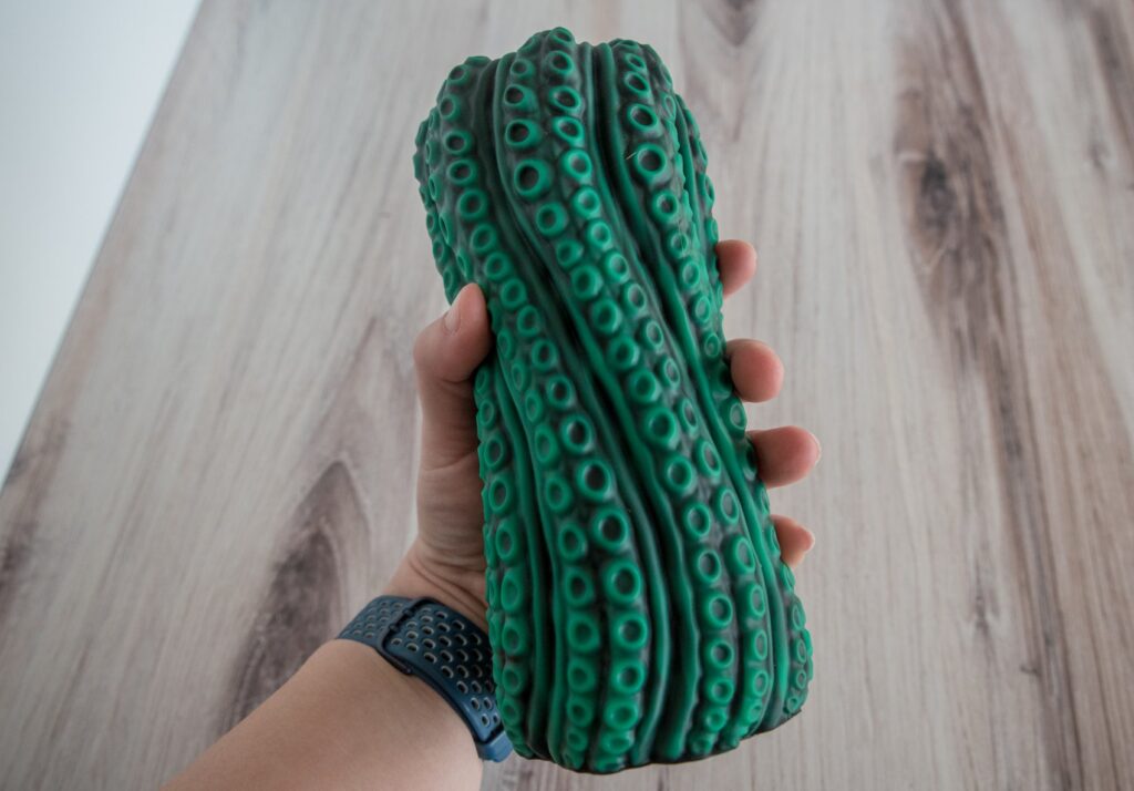 My hand holds the Vortima. It is very thick, and my fingers can not close around it at all. They can barely close around one half of it. For my Nothosaur Vortima review.