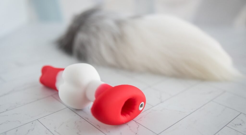 Close-up on the base of the plug with all of the attachments removed. There's a large hole where the bullet vibrator slips inside. There's a small screw-in port where the tail screws in. The base is otherwise flat and oval shaped. For my Juliet Toys Echo review.