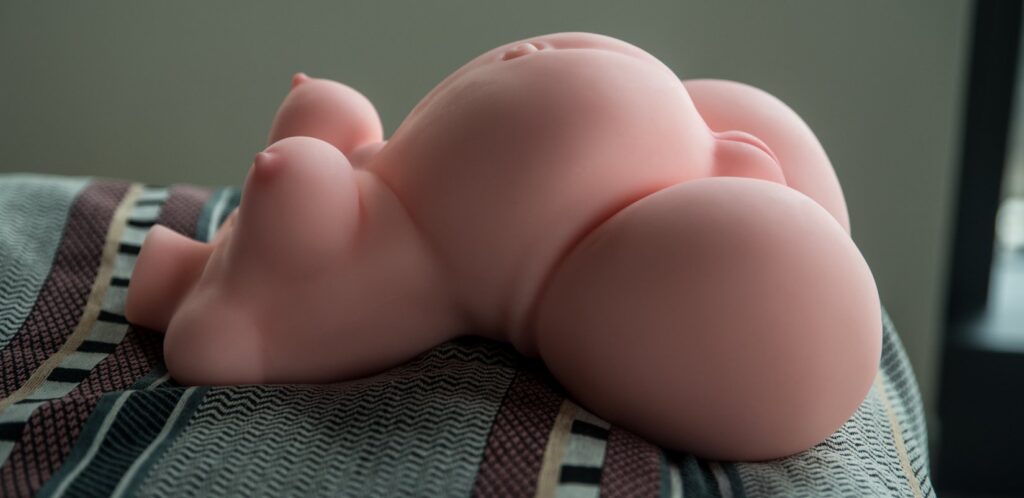 Side view of the sex doll. The pronounced, pregnant tummy is very large and a centerpoint of the sex doll.