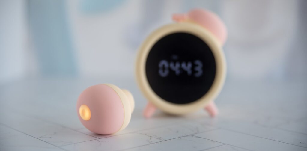 Close-up on the top of the air suction toy, the control button for the suction intensities backlit from being turned on. For my BeYourLover Naughty Alarm Clock review.
