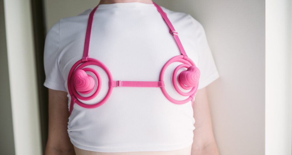 A person wears the Vkini over a white shirt, showcasing how the Vkini fits on the body. The front view shows where the cups lie if they're as loosely together as possible. For my VVD Vkini review.