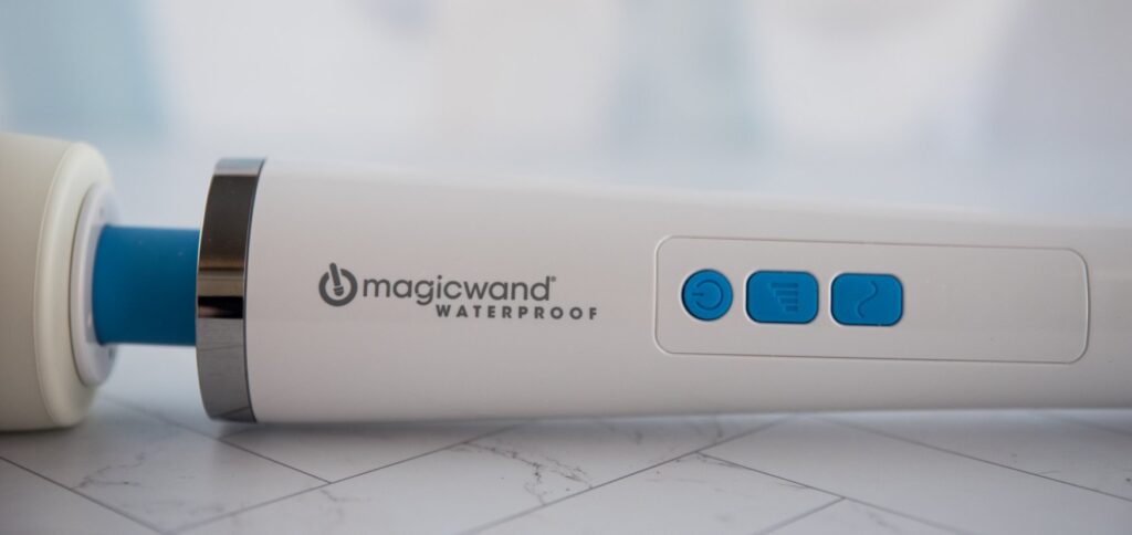 Close-up on the three buttons that control the power and vibrations on the wand massager.