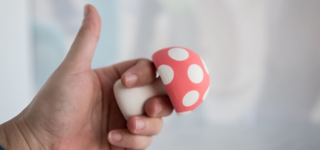 My fingers hold the vibrator. It easily fits between my pointer and middle finger at its narrowest point with a thicker base and mushroom "cap" that keeps the toy nicely nestled. For my Mushroom Vibez review.