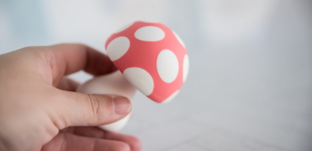 My fingers hold the vibrator. The toy looks small and lightweight in my fingers. For my Mushroom Vibez review.