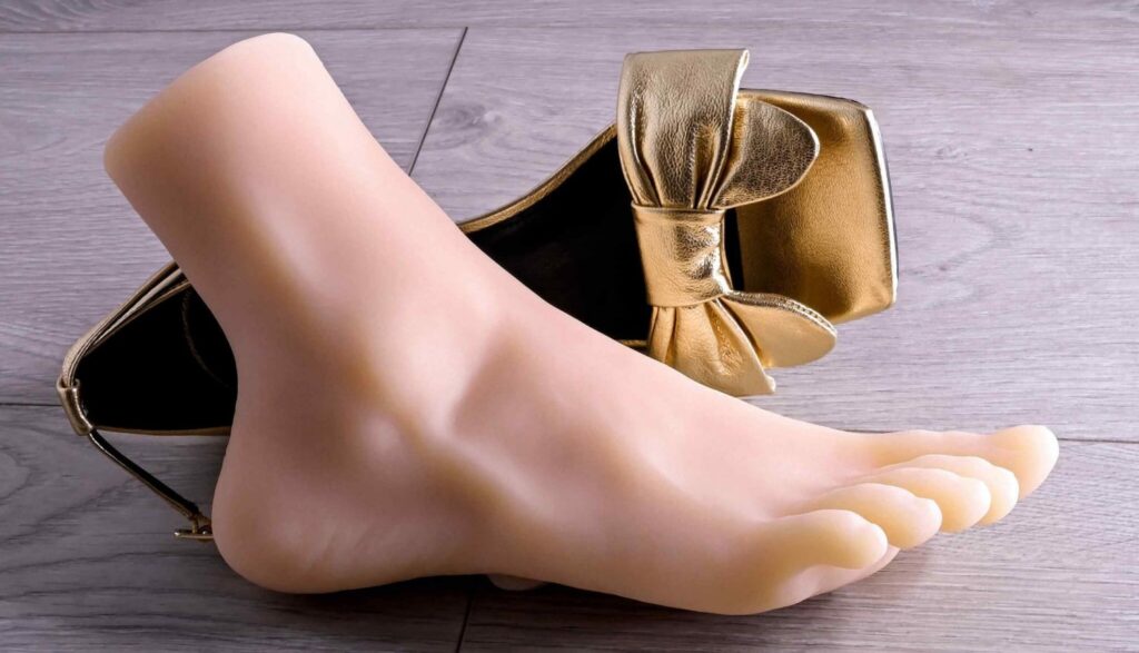 Evolved Pussy Footin' stroker shown next to a high-heeled gold shoe