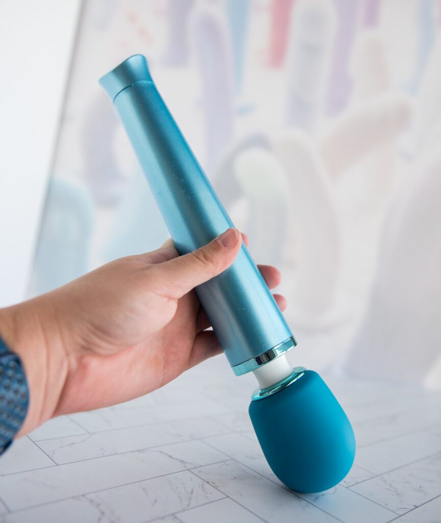 My hand holds the wand, pressing it down into the ground. The head of the massager doesn't bend; it doesn't have much of a flexible massage neck. The massager is larger than many petite wands but smaller than most full-sized wands. For my Le Wand Dive review.
