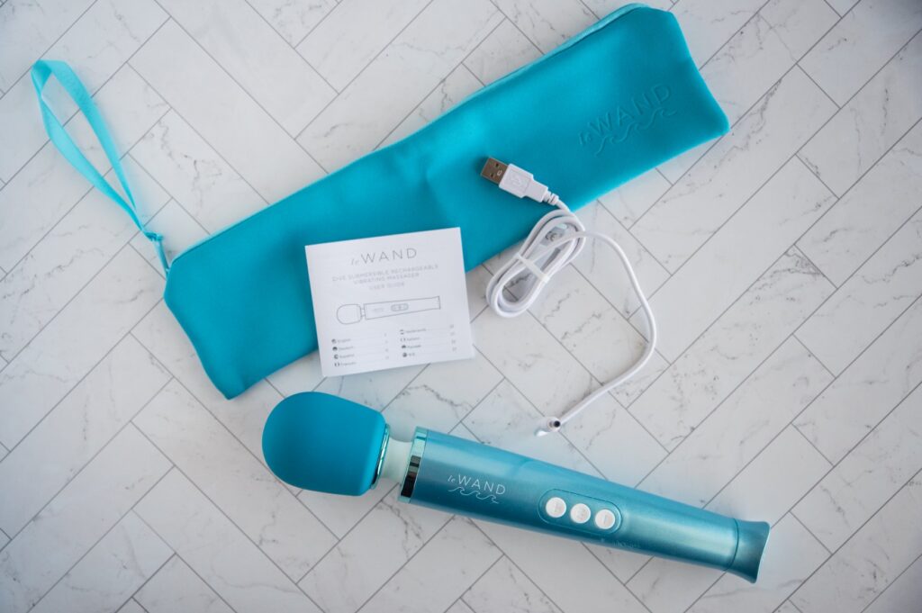 Top-down view of everything included with the Dive including the zip-up color-matching storage pouch, the charging cable, the instructions, and the wand itself.