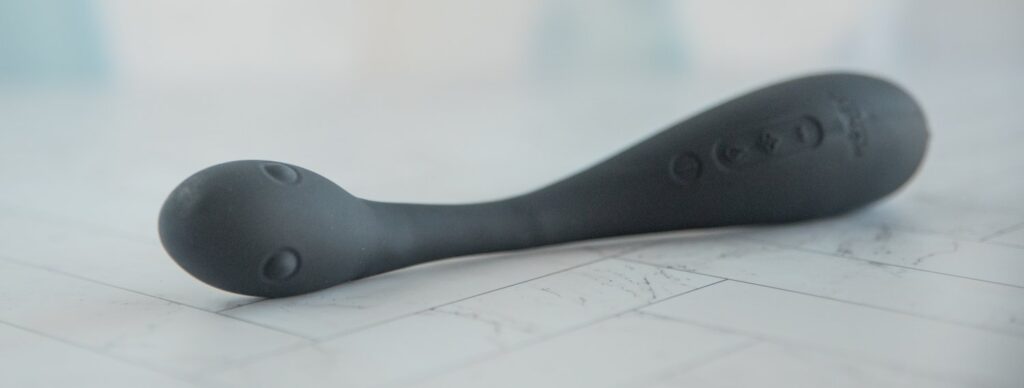 The AIRA lies on its side, showcasing the bulbed design of the tip. For my Honey Play Box AIRA review.