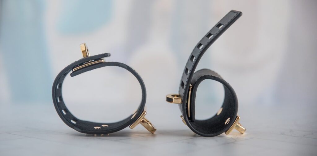 The cuff set shown on its side. One of the cuffs is as tightly as the cuffs wrap while the other cuff is shown on its loosest setting. It's a very large size difference between the two.