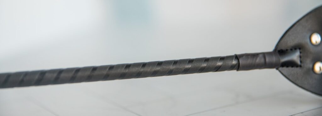 Close-up of the electrosex conductive material along the stem of the riding crop, making the entire length of the riding crop e-stimulation capable. For my Dr. Sado e-Stim Crop review.