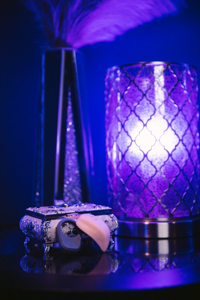 The LuxHer and LuxHim sits out next to a jewelry box. A sensual blue light glows throughout the entire image, putting the whole image in blue. For my Luxus review.