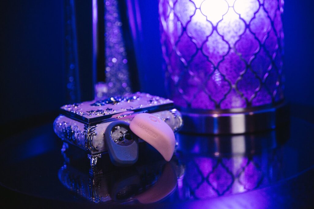 The LuxHer and LuxHim sits out next to a jewelry box. A sensual blue light glows throughout the entire image, putting the whole image in blue. For my Luxus review.