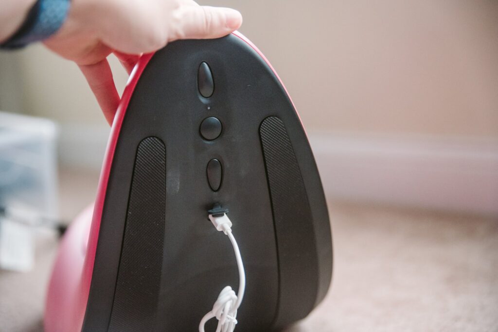 The Rider Desire plugged into its charging cable. The charging port is underneath the Rider Desire.