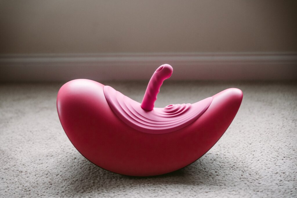 The sex toy sitting out on the floor, showcasing its unique, extra-curved base. For my VVD Rider Desire review.