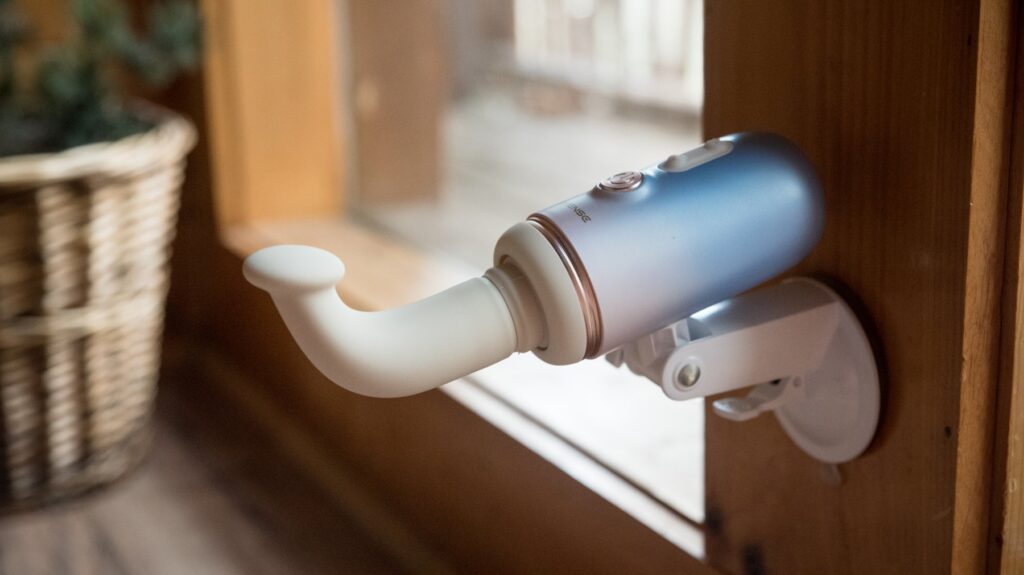 The g-spot attachment shown attached to the sex machine as it's suction cupped to a cabin wall. For my Lovense Spinel review.