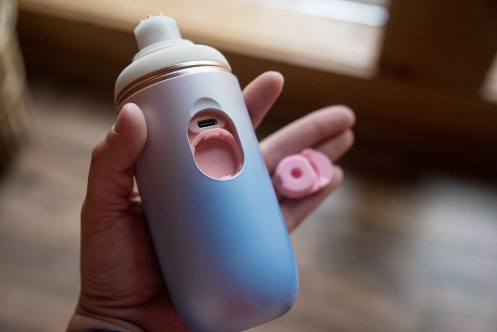 I remove the pink silicone stopper from the machine, showcasing where the attachments snap onto the machine as well as the USB-C charging port. For my Lovense Spinel review.