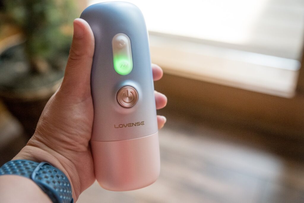 My hand holds the sex machine itself with the lid on, showcasing its small size that easily fits into a hand. For my Lovense Spinel review.