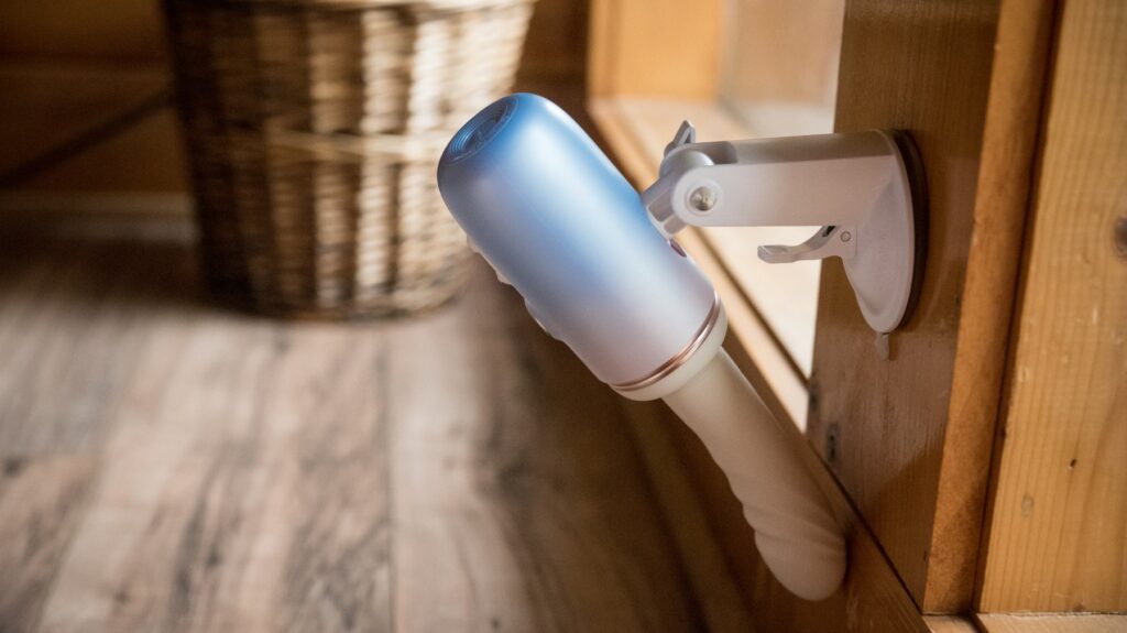 The suction cupped machine is pointing backwards, towards the wall, showcasing how the suction cup attachment allows for a near-360 degree adjustment on the angle.